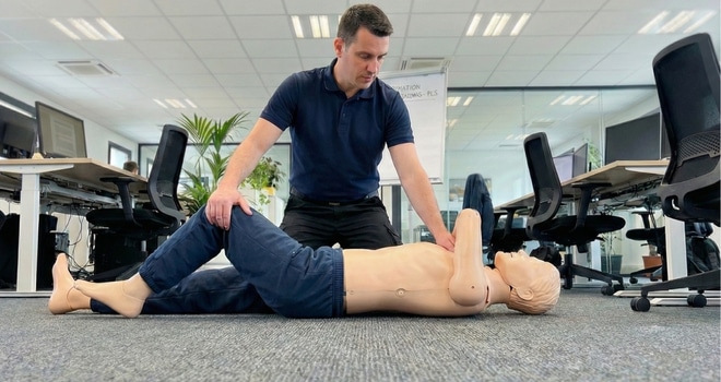 Formateur réalisant une position latérale de sécurité sur un mannequin